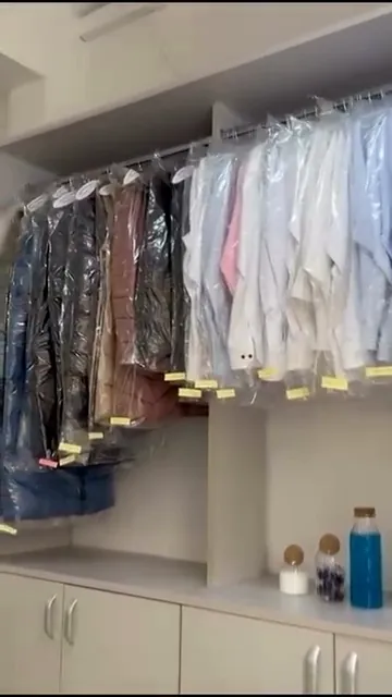Hainele clienților, în husă, cu tichetul galben, gata de ridicare